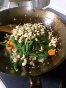 Adding the cashews, sugar snap peas and thinly-sliced carrots and celery. 